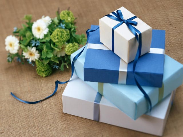 Paquets cadeaux bleus et bouquet de fleurs